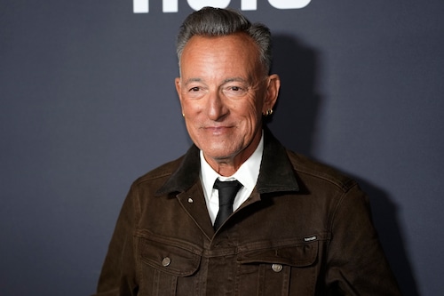 Bruce Springsteen performing on stage during his 2025 tour, smiling and engaging with the audience