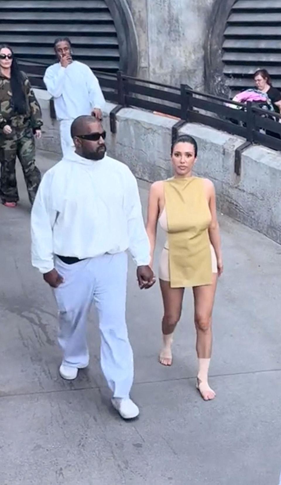 Bianca Censori posing in a daring fashion ensemble alongside Kanye West