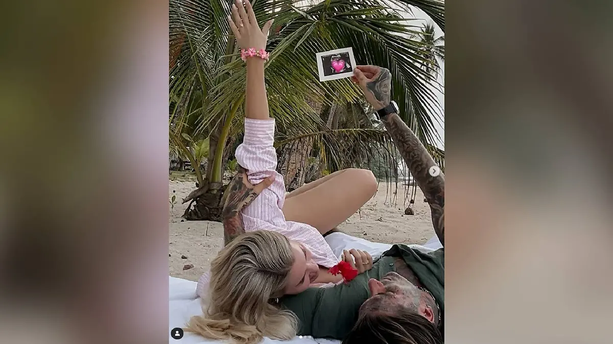 Kim Virginia streichelt ihren Bauch am Strand